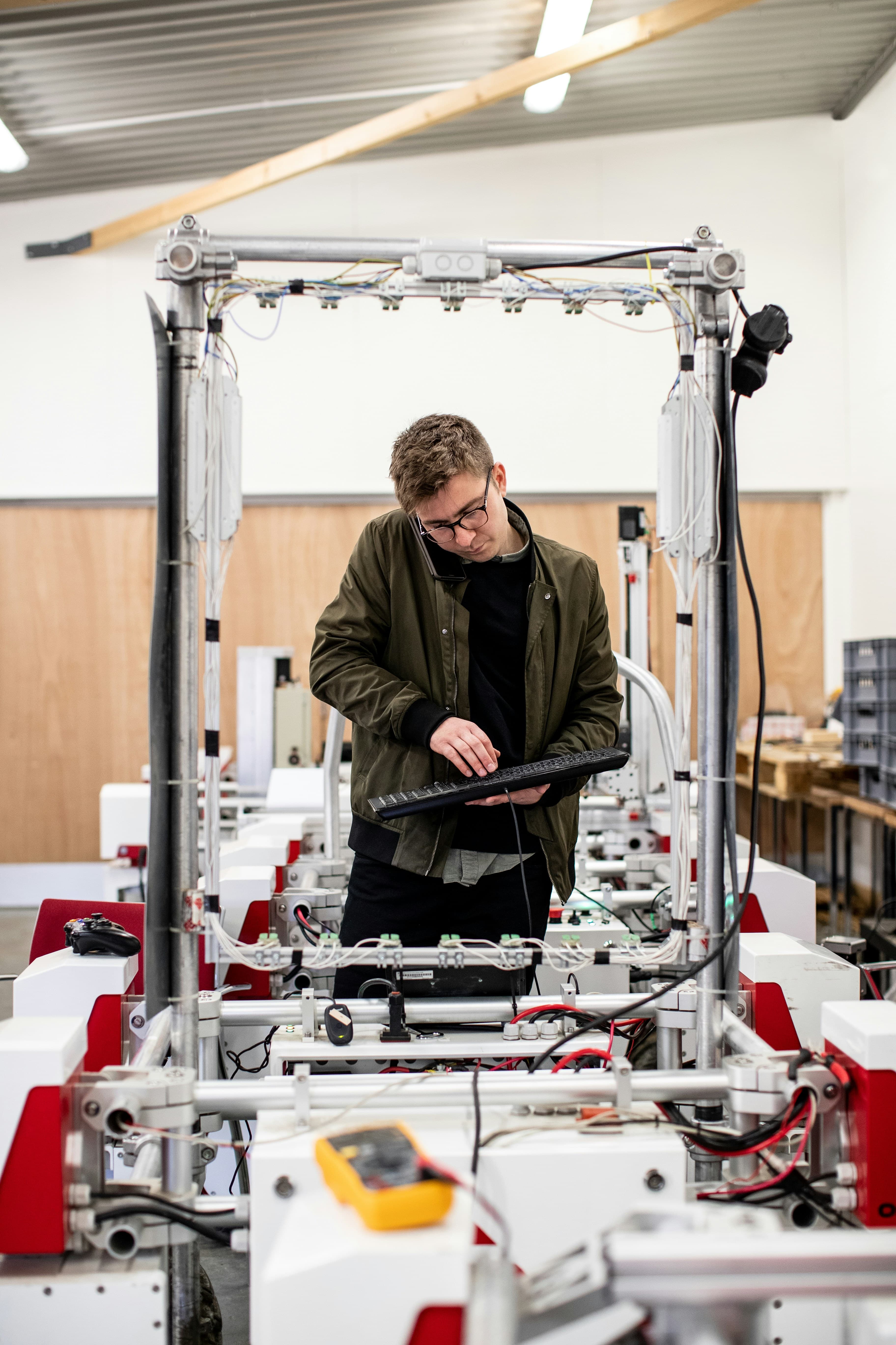 Un technicien règle une machine avec un clavier dans un atelier de production.